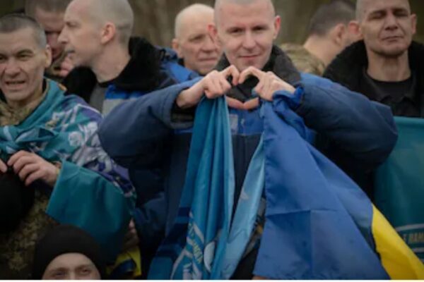 Ukrainian service members, draped in their national flags, celebrate their release from Russian captivity following a UAE-brokered prisoner exchange in April 2026